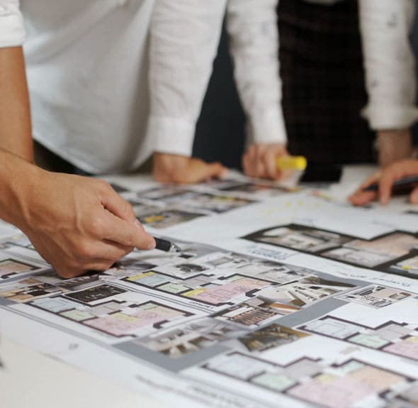 architects and designers discus floorplan for an open-concept office redesign