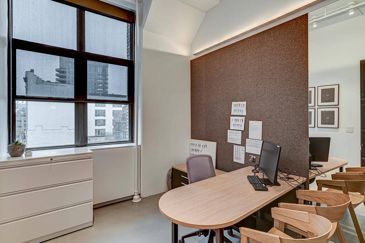 Modern office that plays with functional accent walls that double as a corkboard
