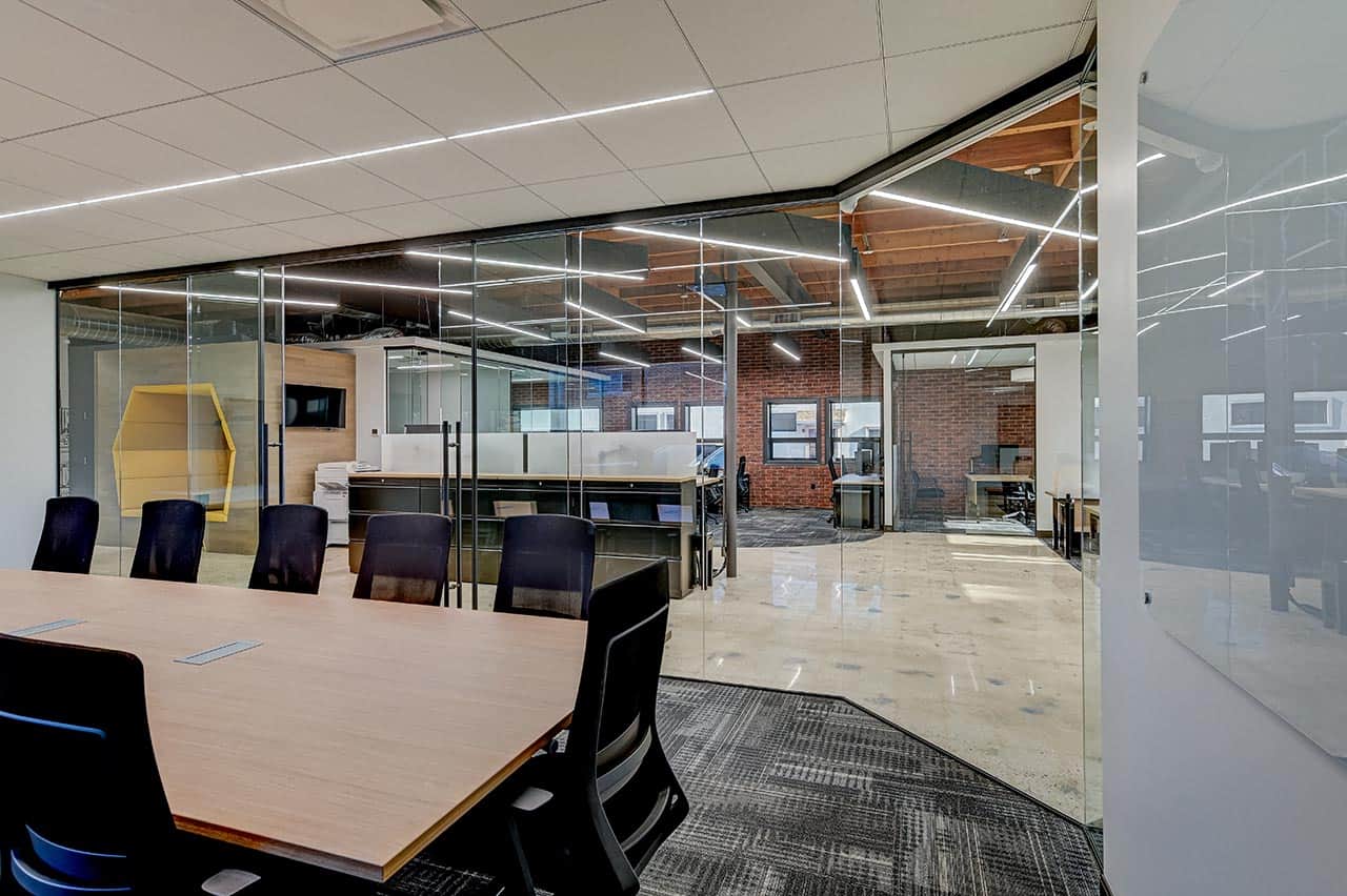 Modernized boardroom with wrap around glass walls to allow for natural light