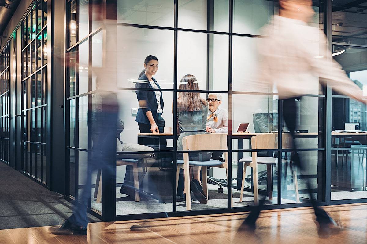 Employee's using a new meeting room in office that was recently redesigned to allow for greater collaboration