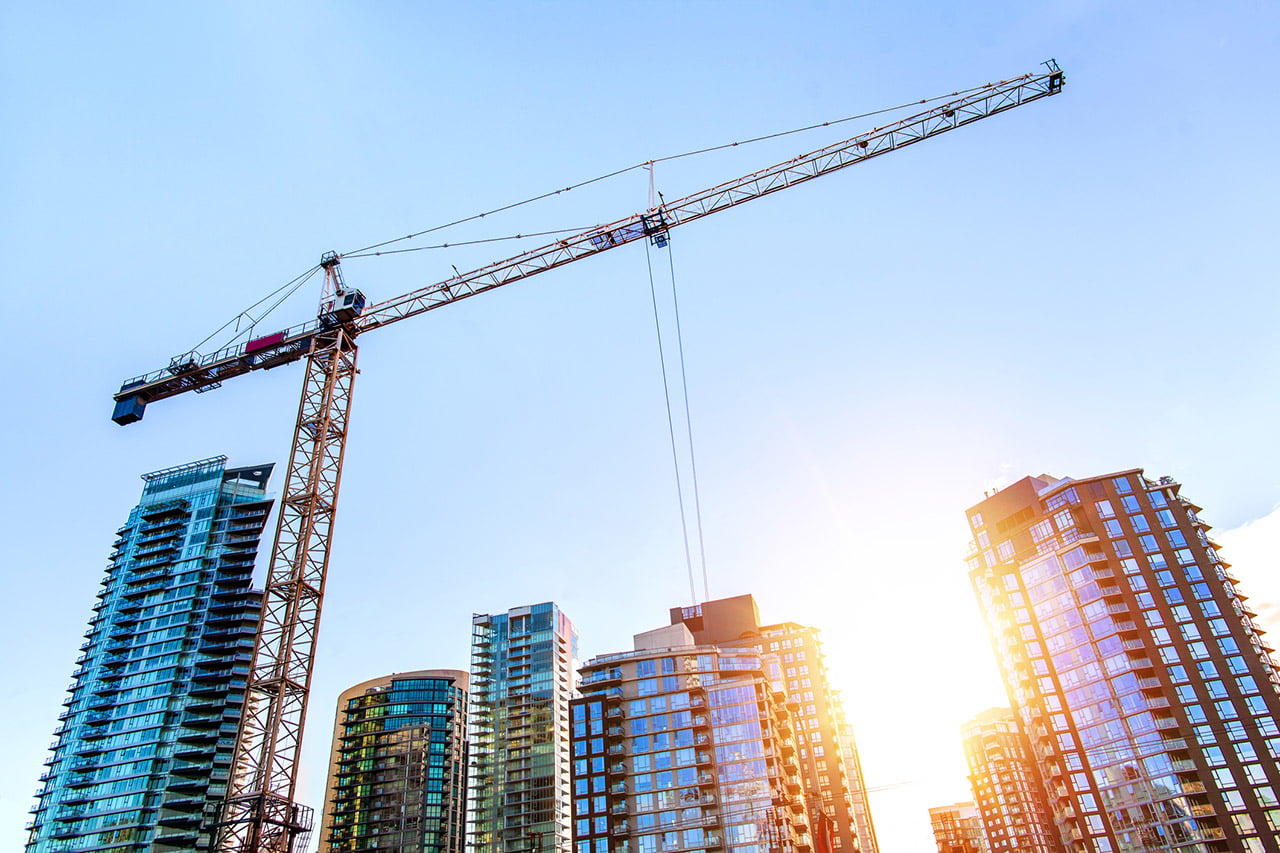 A tower crane working with skyscrapers in the skyline