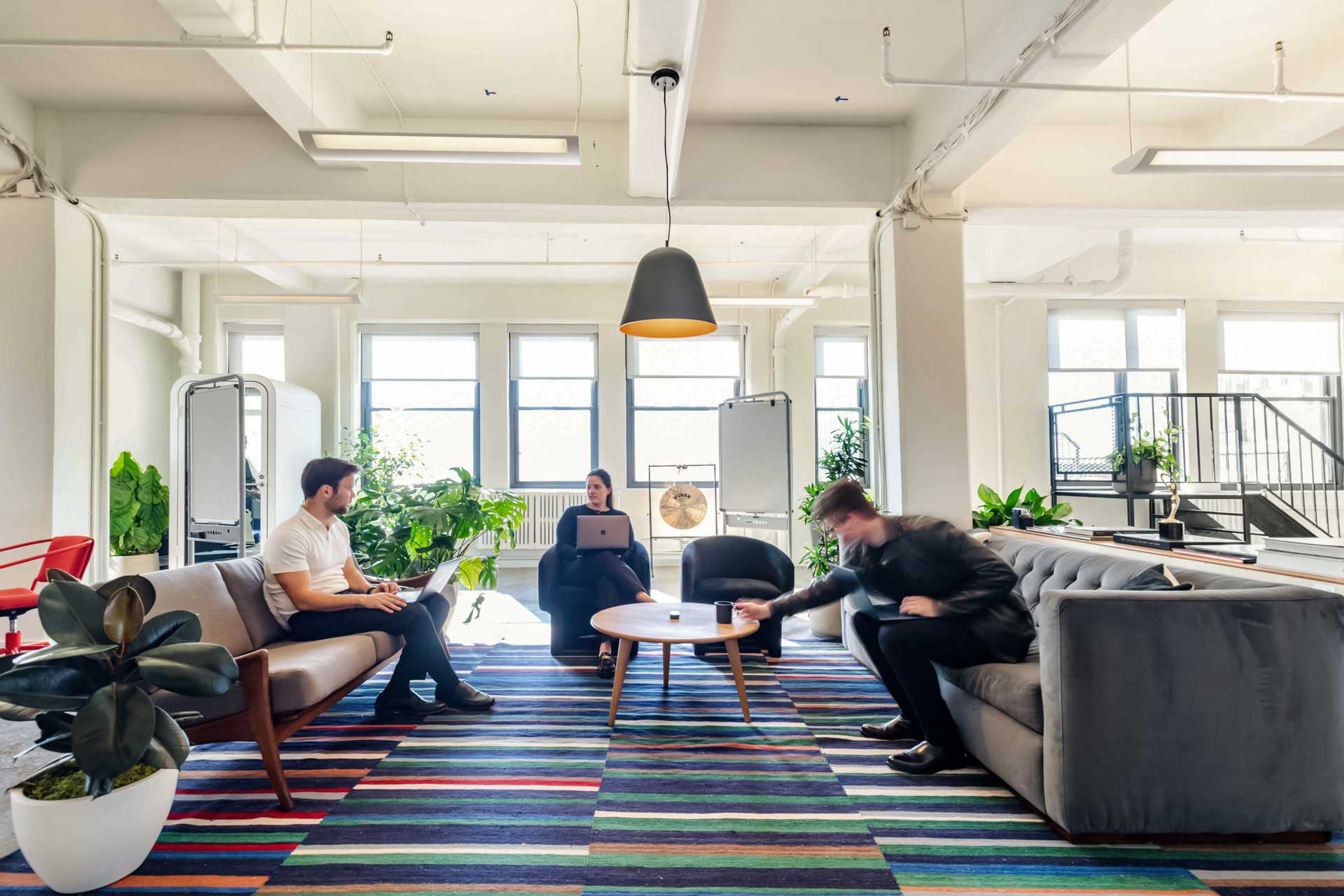 Open plan workspace with collaborative zones, private seating areas and natural lighting designed for hybrid work and return-to-office trends.