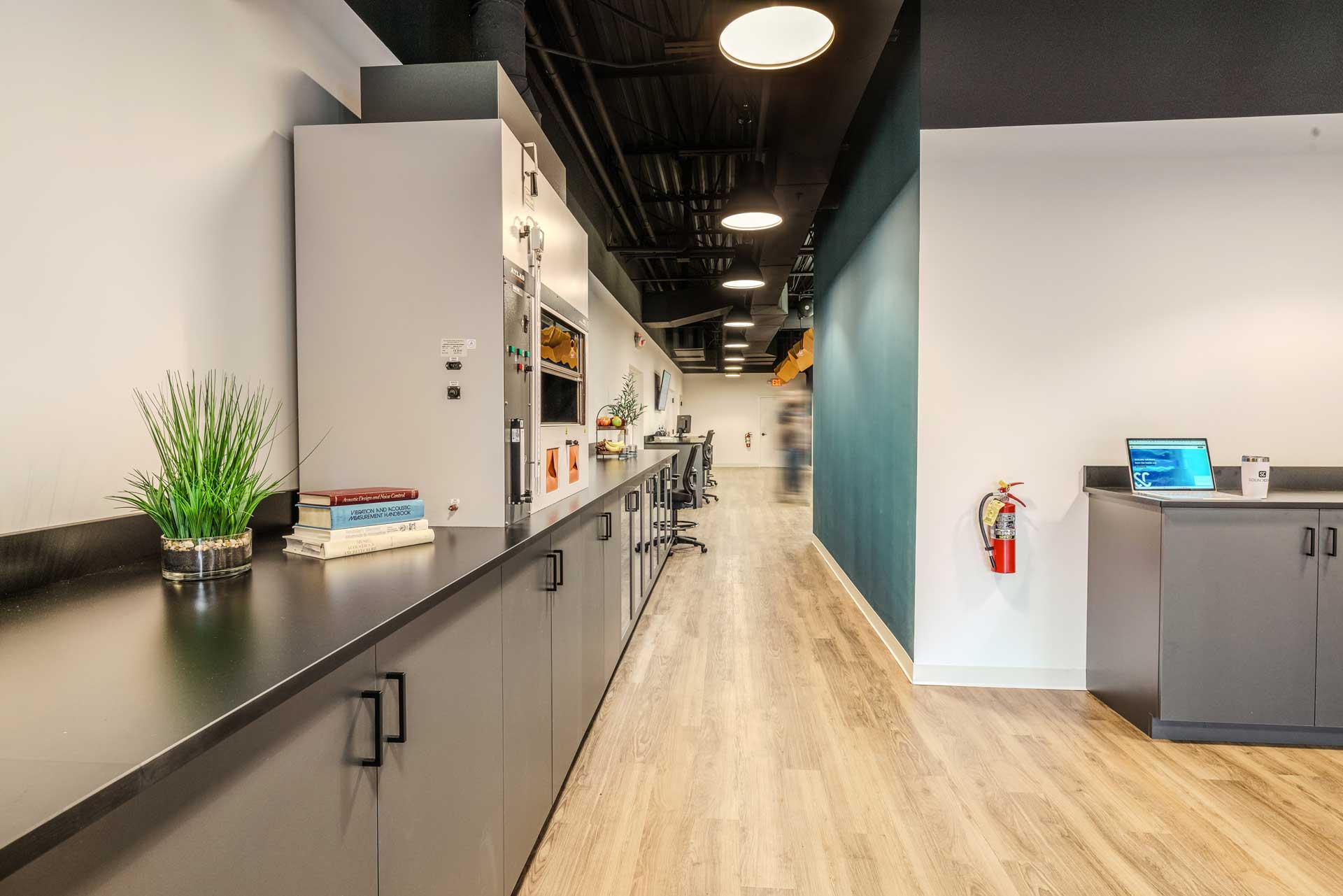 Renovated acoustics lab at Soundcoat redesigned by RI Workplace, featuring modern cabinetry, safety equipment, and a streamlined workspace layout for advanced product testing.