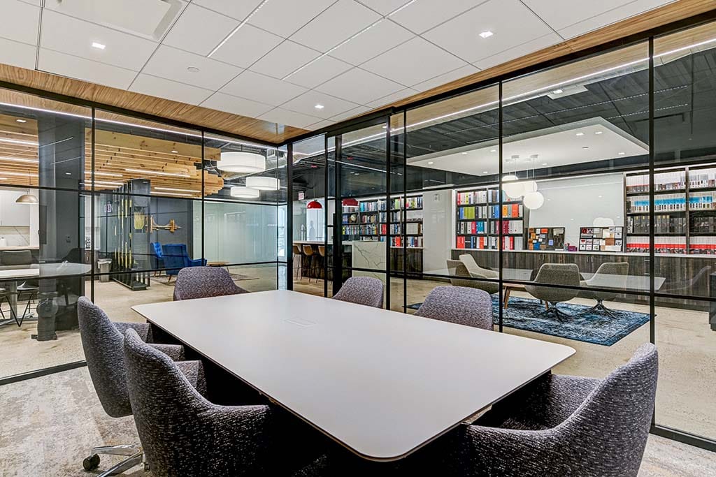 Office interior shot from a board room, fitted with glass paneling with a view into the open spaced office area 