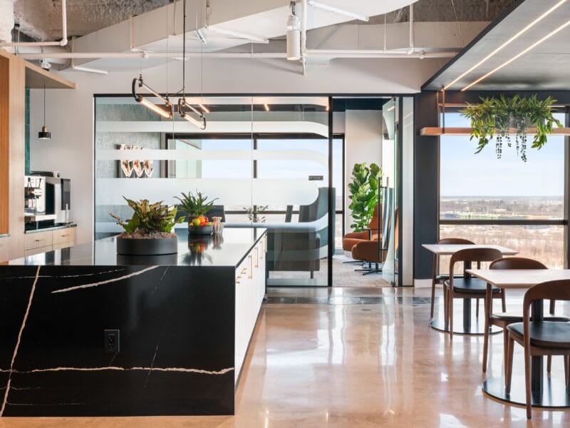 Modern office café area in LS Power workplace retreat with kitchen island, seating, and glass meeting rooms in New Jersey