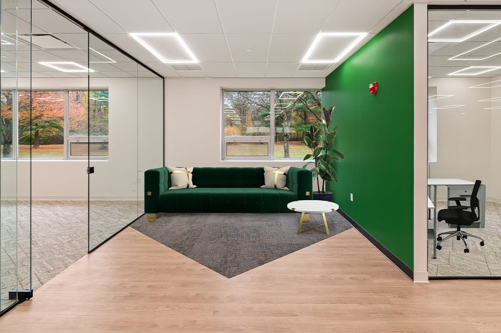 Modern office rest station equipped with bold dark green colours and contrasting wood