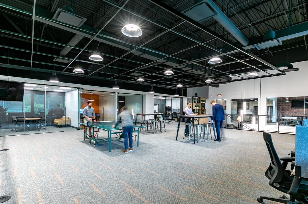 Modern office with open plan layout, staff using the facilities and enjoying a lunch break